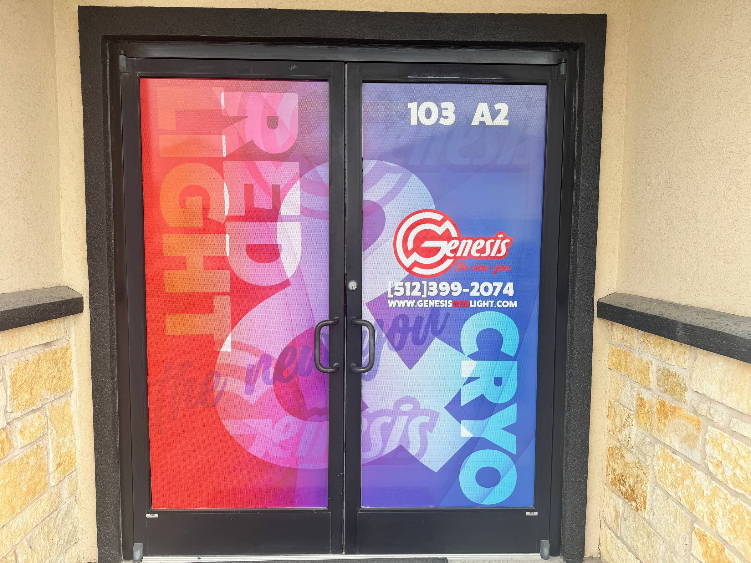 The Genesis Red Light front door, Ste A2 (103 A2 on the glass), with the clinic phone number and Red Light and Cryo artwork