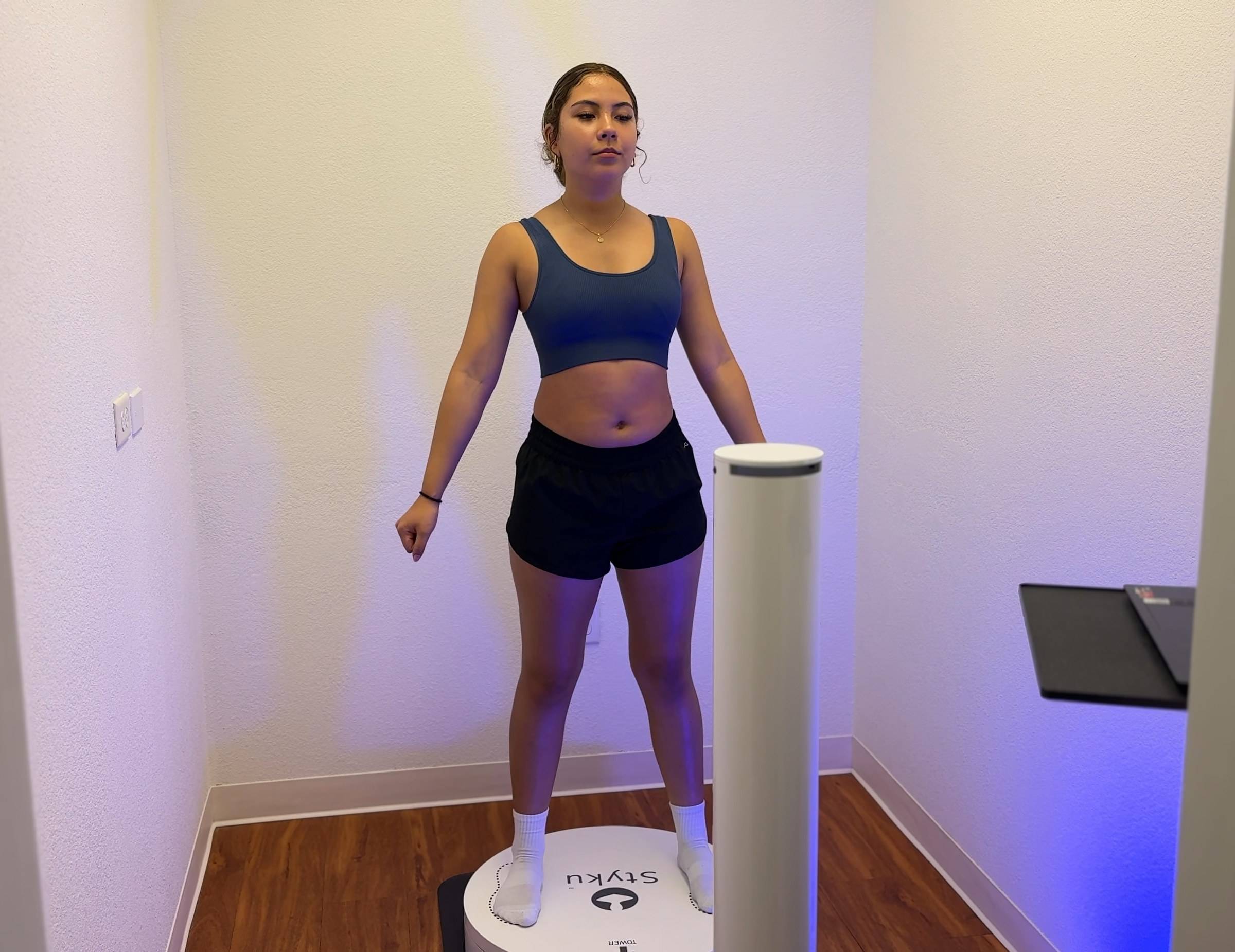 A woman standing on the Styku 3D body scanner turntable during a private scan at Genesis Red Light in Cedar Park, TX
