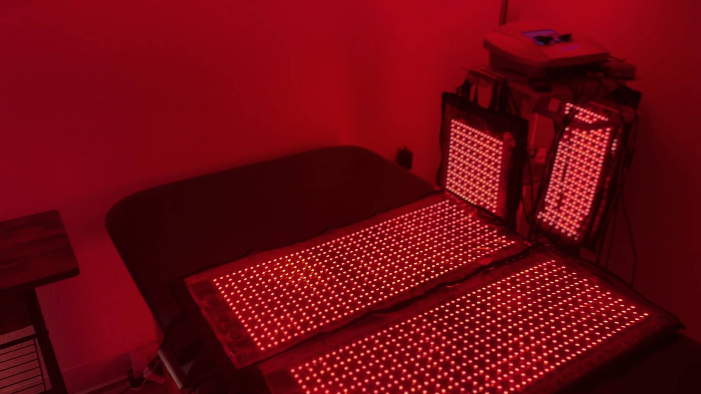 Contour Light red light pads glowing on a treatment bed in the Genesis Red Light room in Cedar Park, TX
