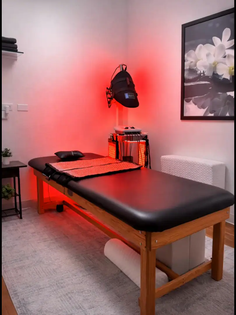 A private red light room at Genesis Red Light in Cedar Park, with the Contour Light device over the treatment bed